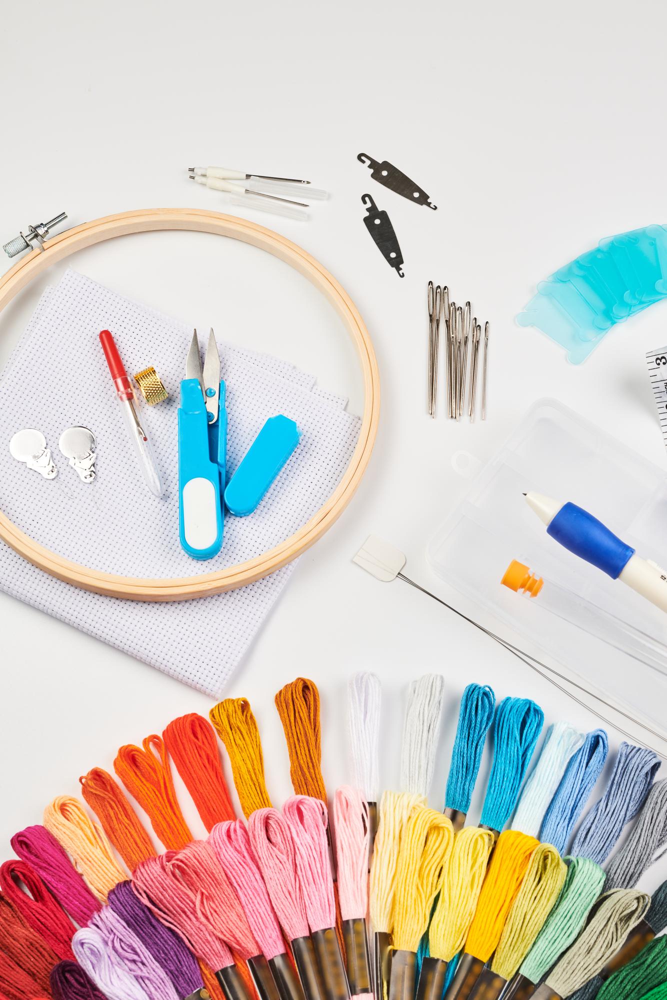Assorted embroidery kits and tools arranged on table